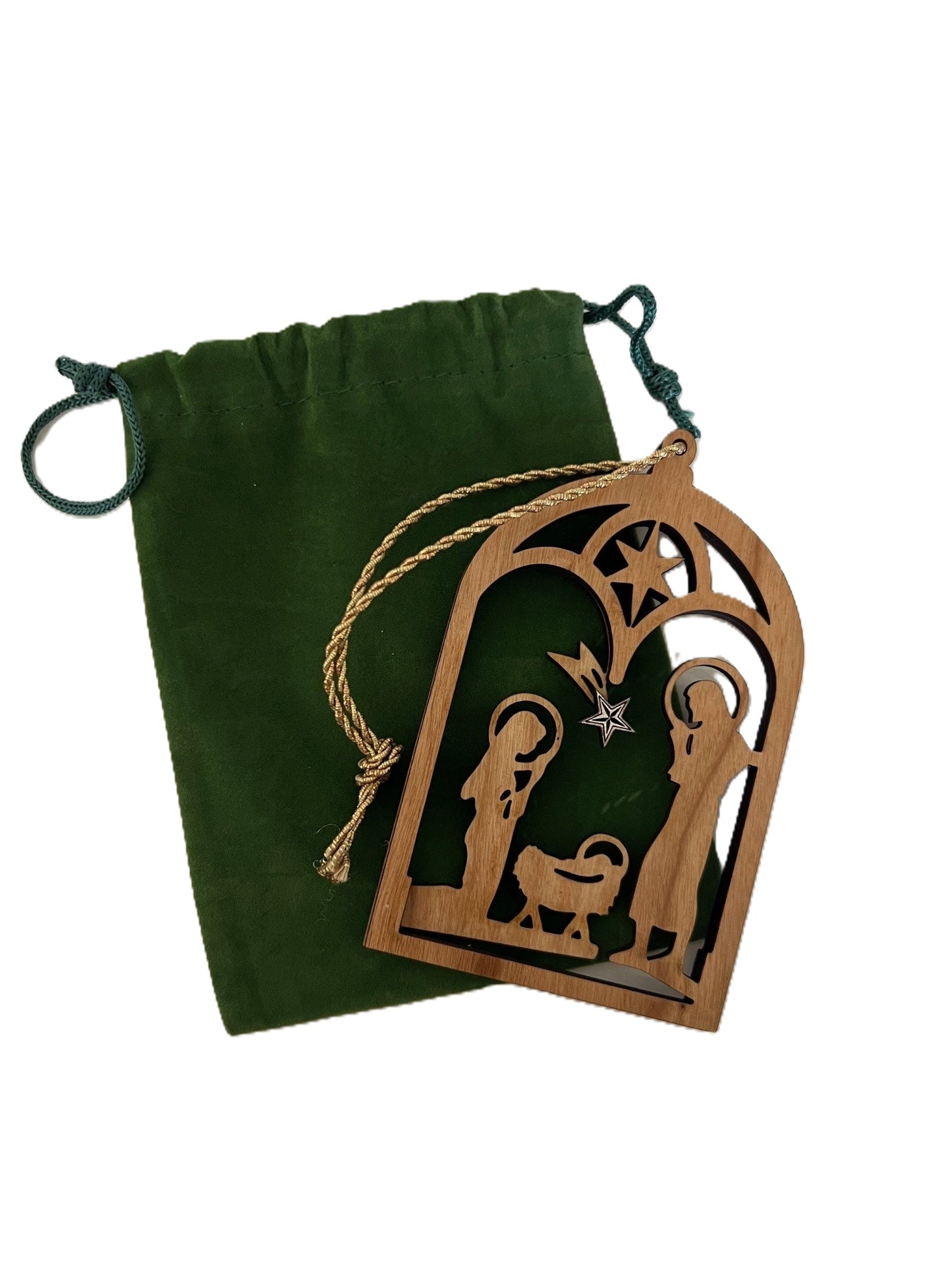 3D Wooden nativity scene ornament laying on a green drawstring velveteen bag.