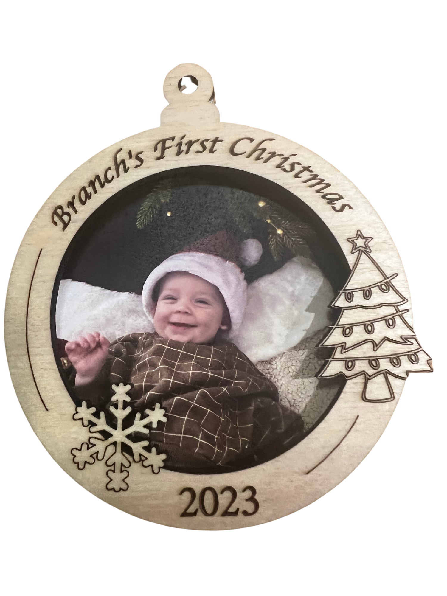 A photo ornament with Christmas tree, a photo of a baby and the text "Branches First Christmas 2023".